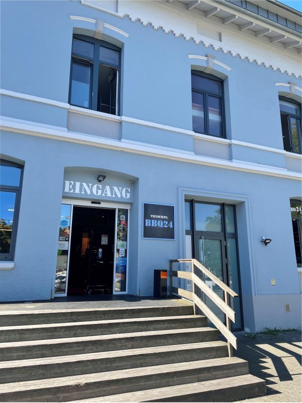 Eingang zum BBQ24 Store im blauen Gebäude in Ravensburg